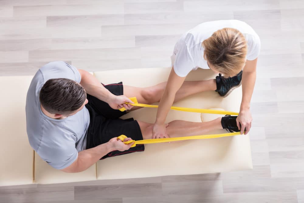 Physical Therapist with patient stretching.